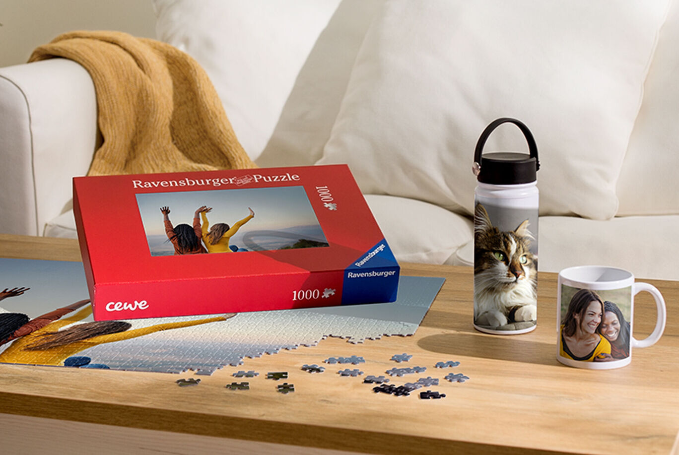 A cozy table with a Ravensburger puzzle, a cat-themed drink bottle, and a mug with a photo of two people.