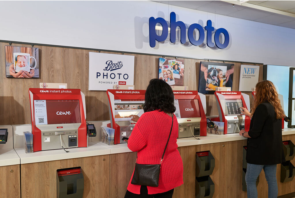 Three people using an instant photo printer in a bright environment